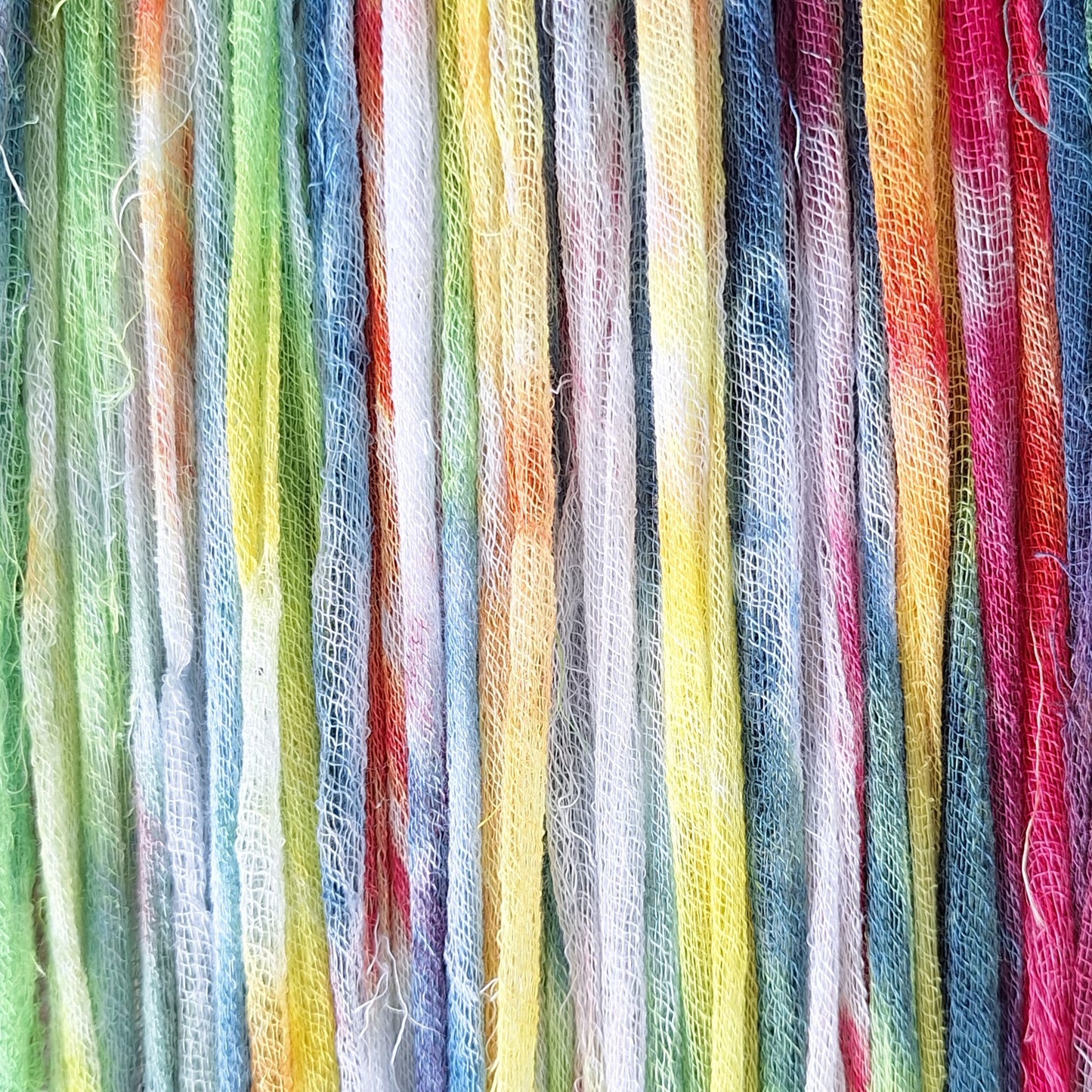 Close-up of colorful cotton gauze ribbon strands in a rainbow pattern