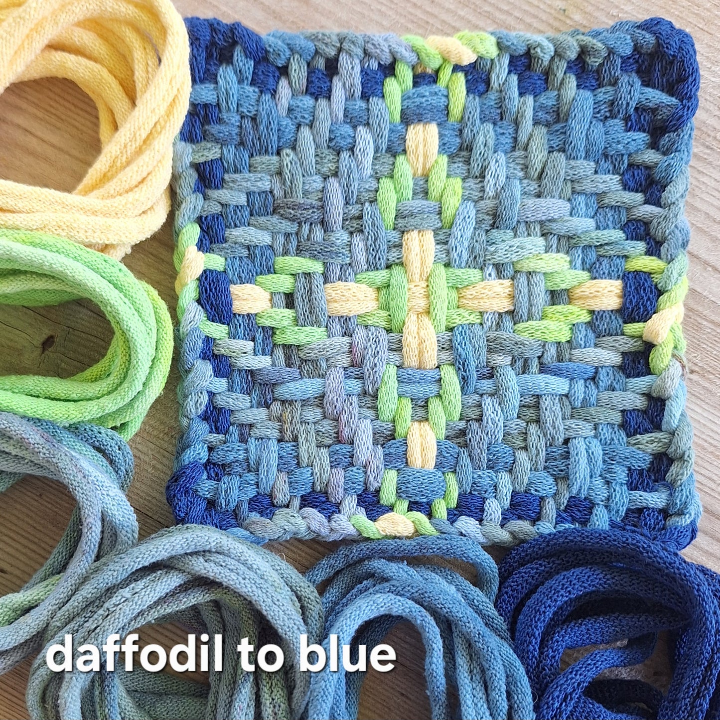 Chunky Star woven potholder with handy dyed loops showing color transition from daffodil to blue on a wooden surface.