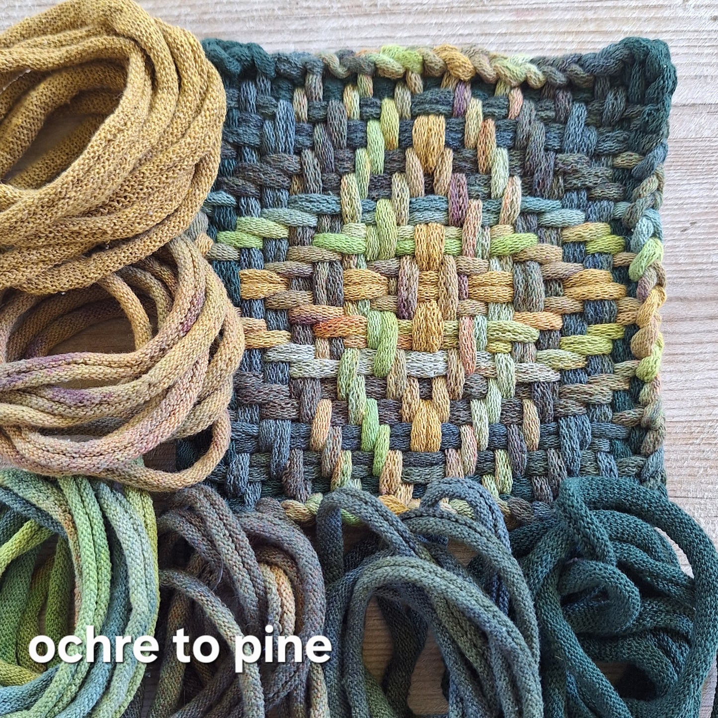 Woven Chunky Star potholder with a gradient of colors from ochre to pine, next to loops used.