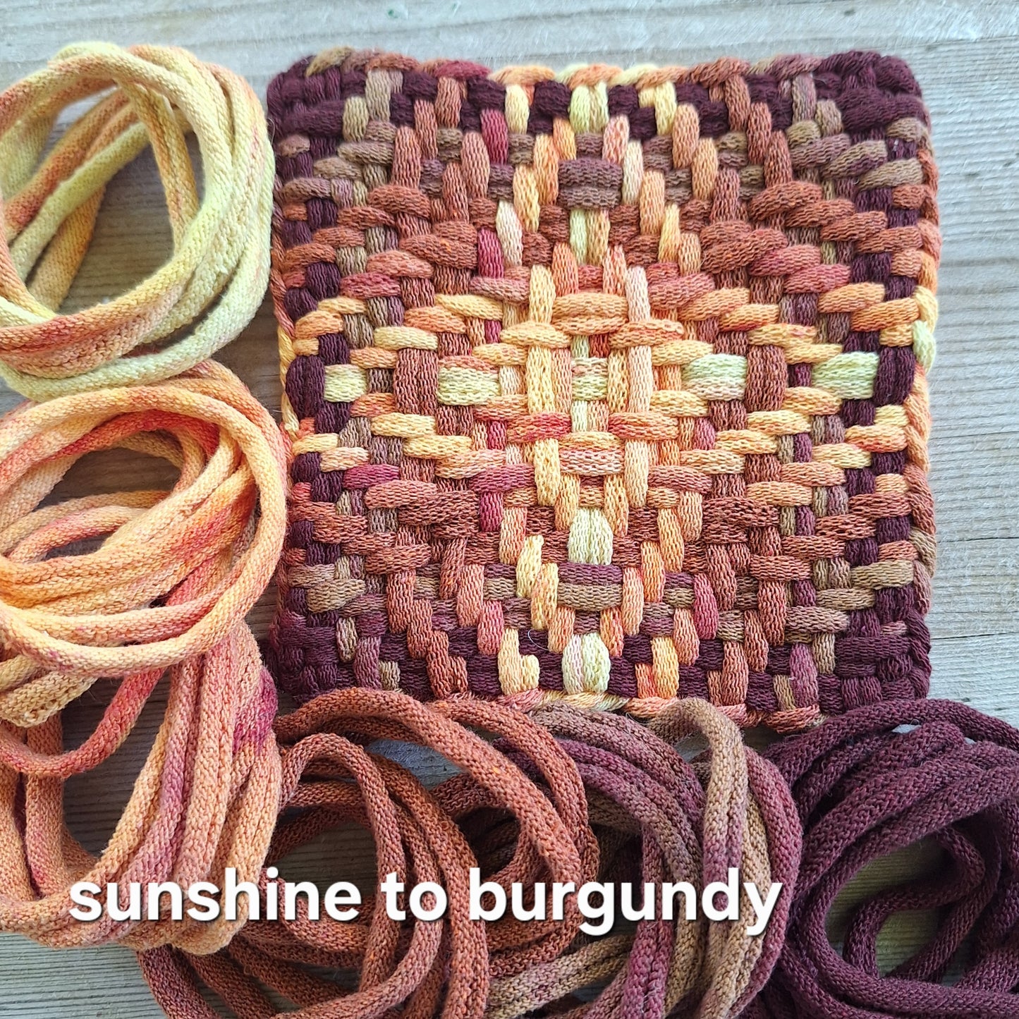 Chunky Star woven potholder with handy dyed loops showing color transition from sunshine to burgundy on a wooden surface.