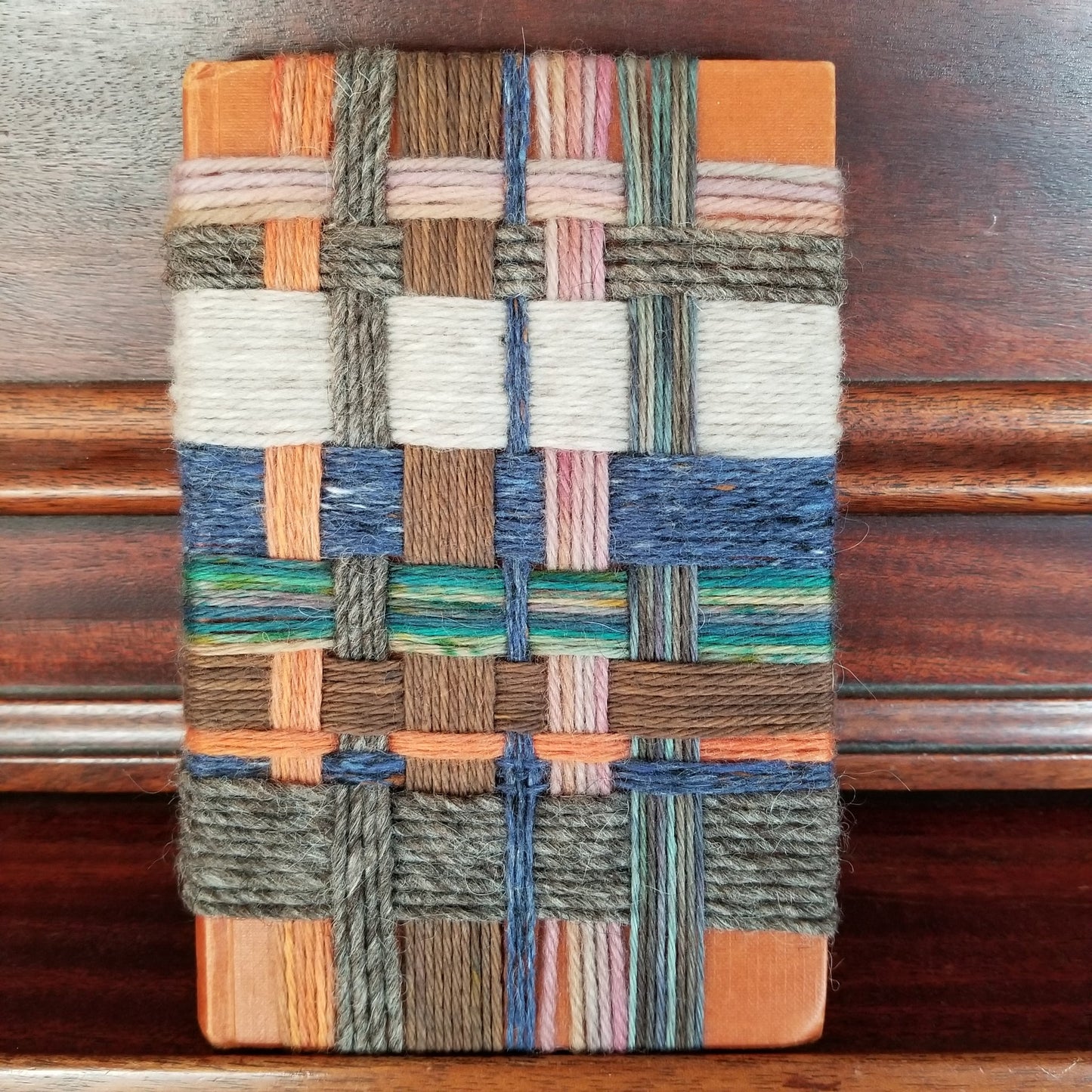 Woven sample with multicolor pattern on a wooden surface