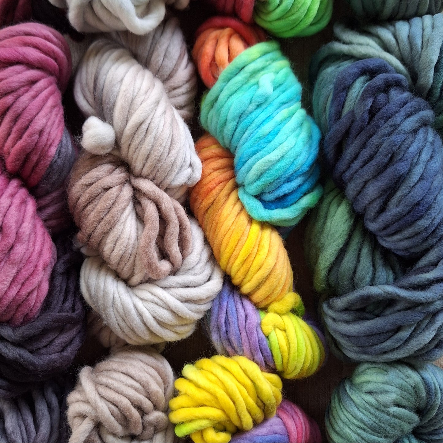 Assorted colorful skeins of pencil roving yarn