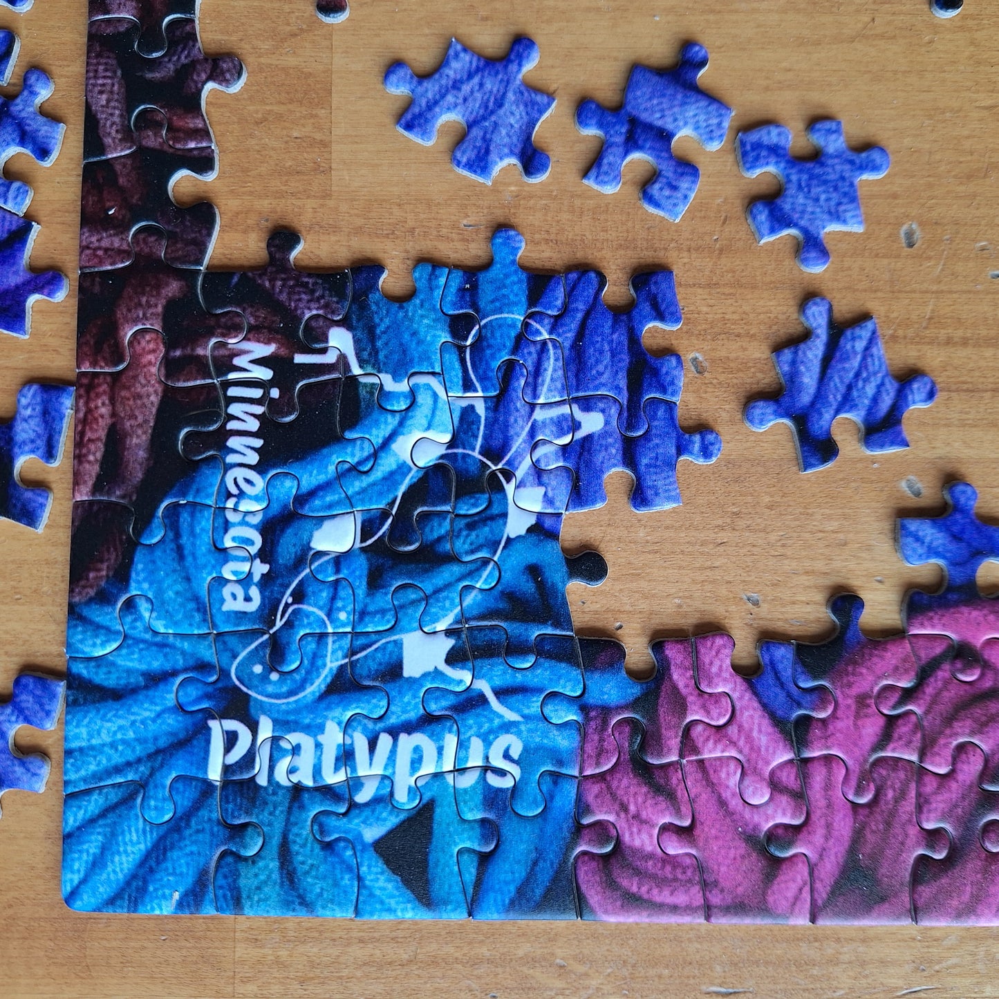 MNPlatypus Jigsaw puzzle with partially completed design on a wooden table