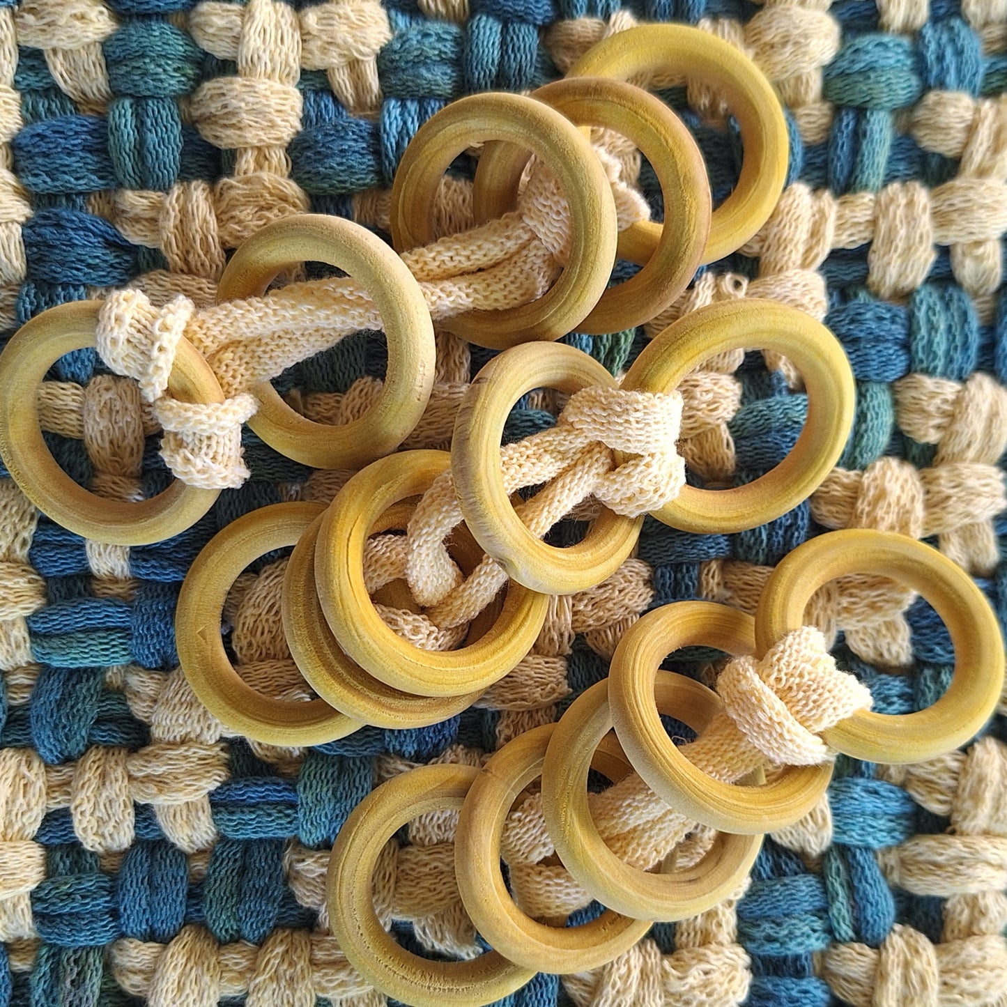 sets of yellow dyed wooden rings on a woven textile background