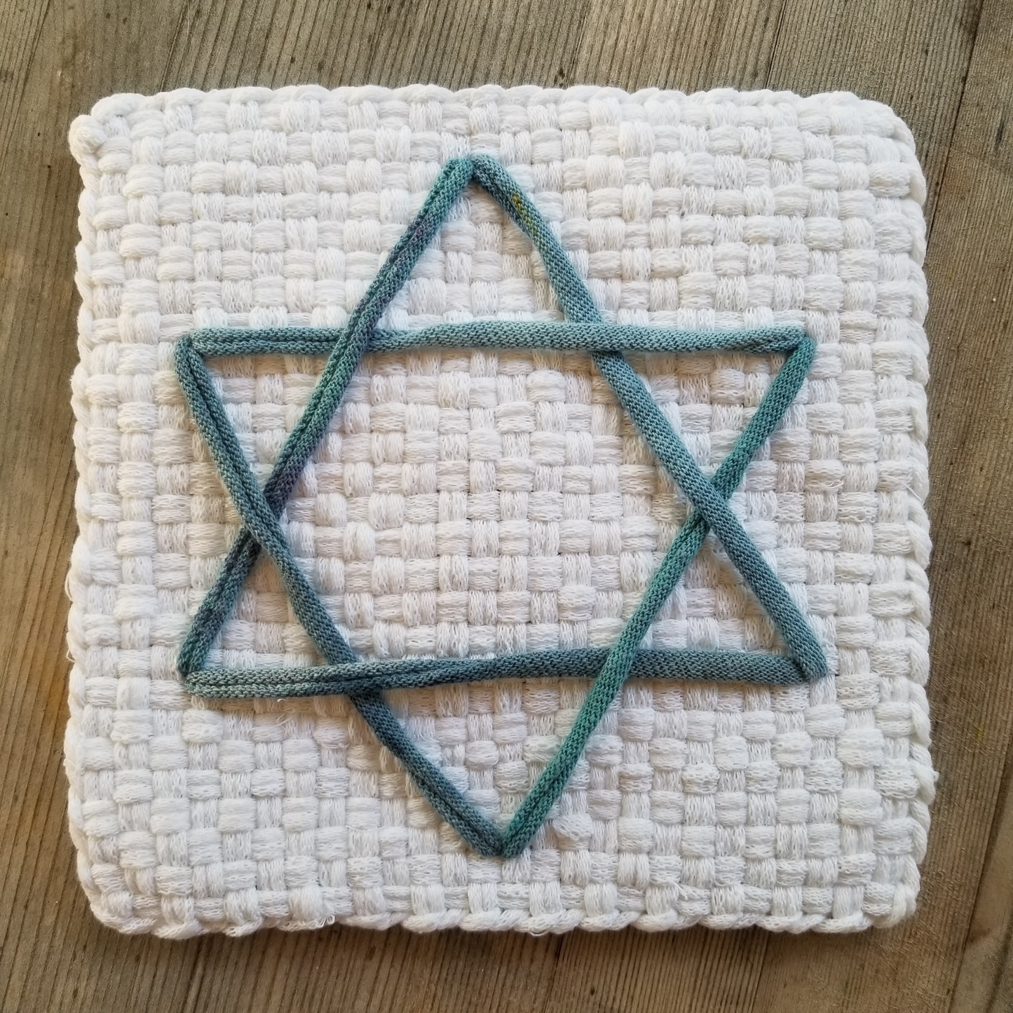 White woven potholder with an integrated blue Star of David decoration