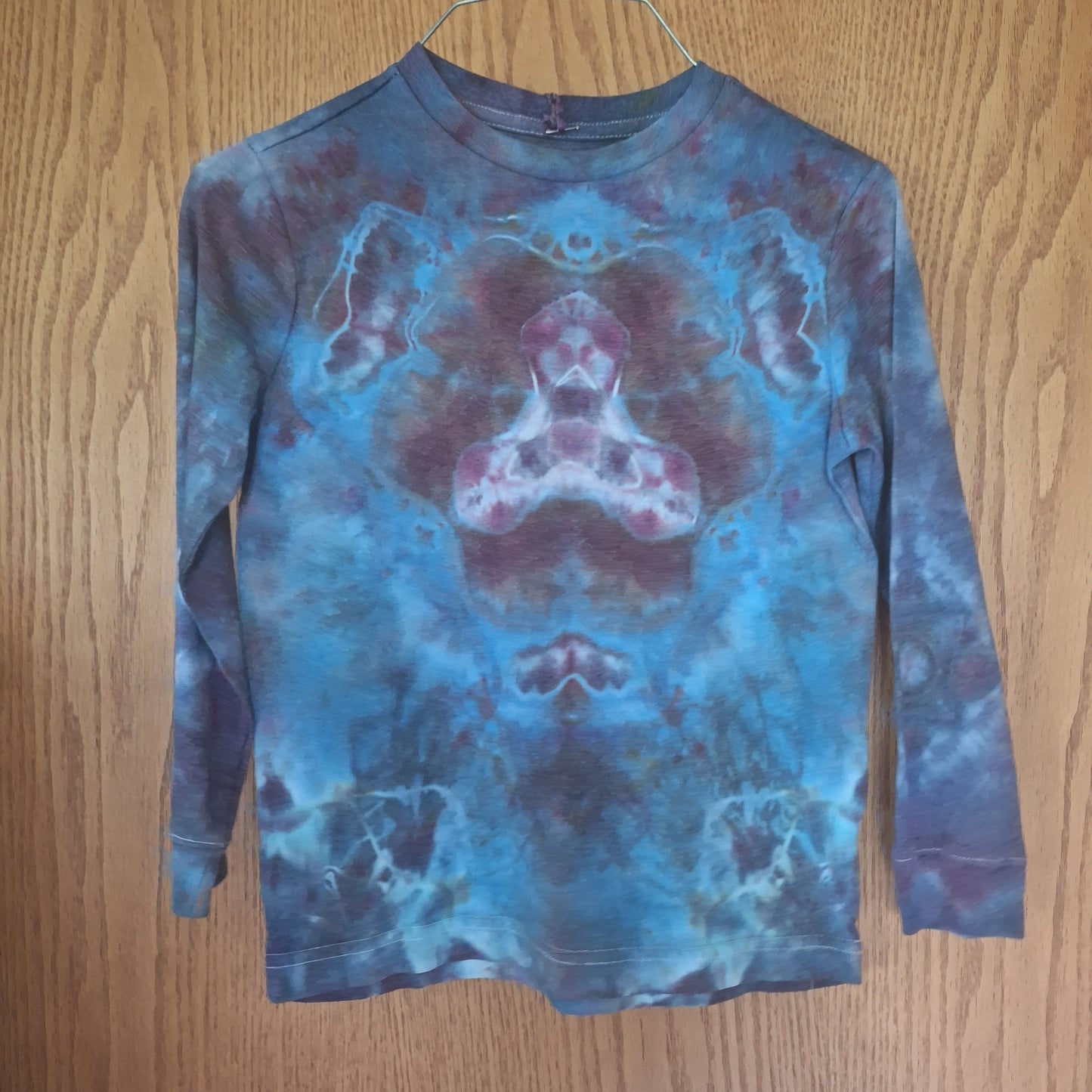 Blue and purple tie-dye long-sleeve shirt on a wooden surface