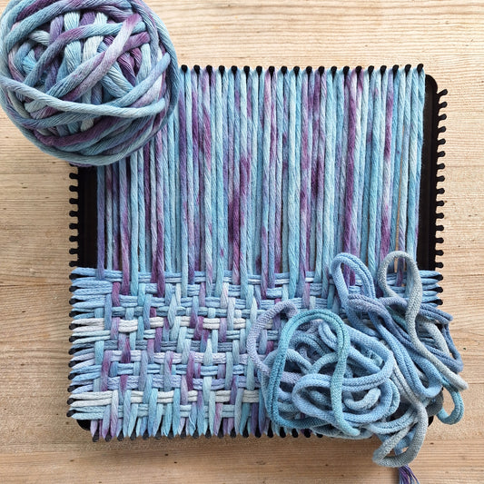 potholder weaving in progress with forget-me-not cotton macrame cord and light blue loops