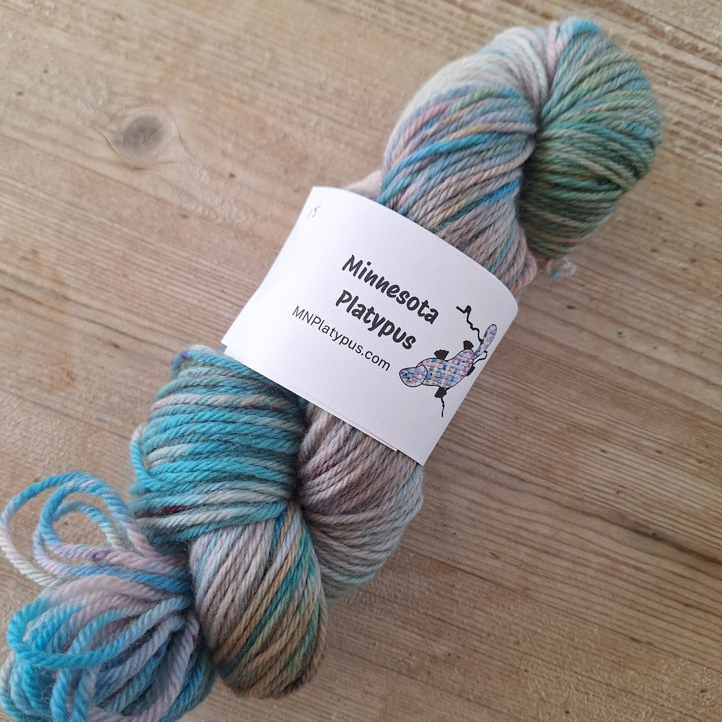 Multicolored skein of yarn with a label on a wooden surface