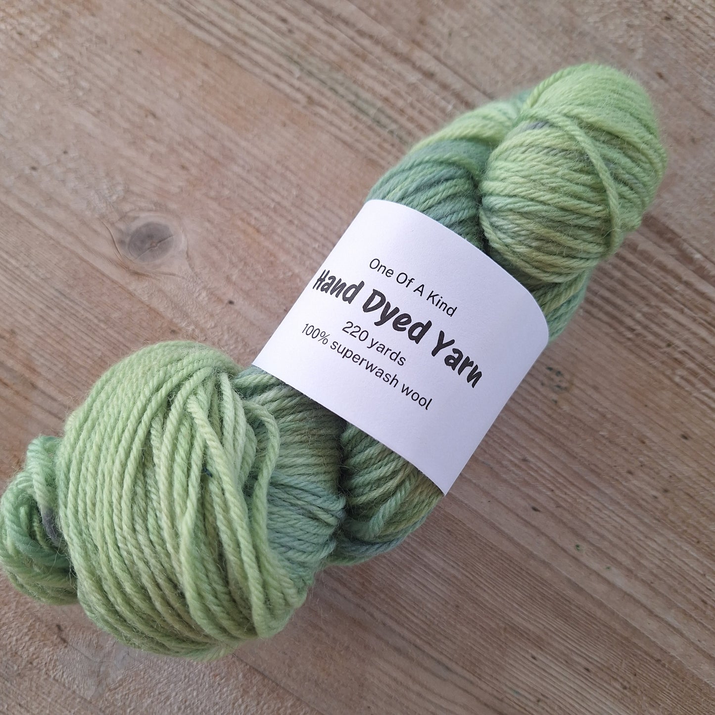 Green skein of yarn with a label on a wooden surface