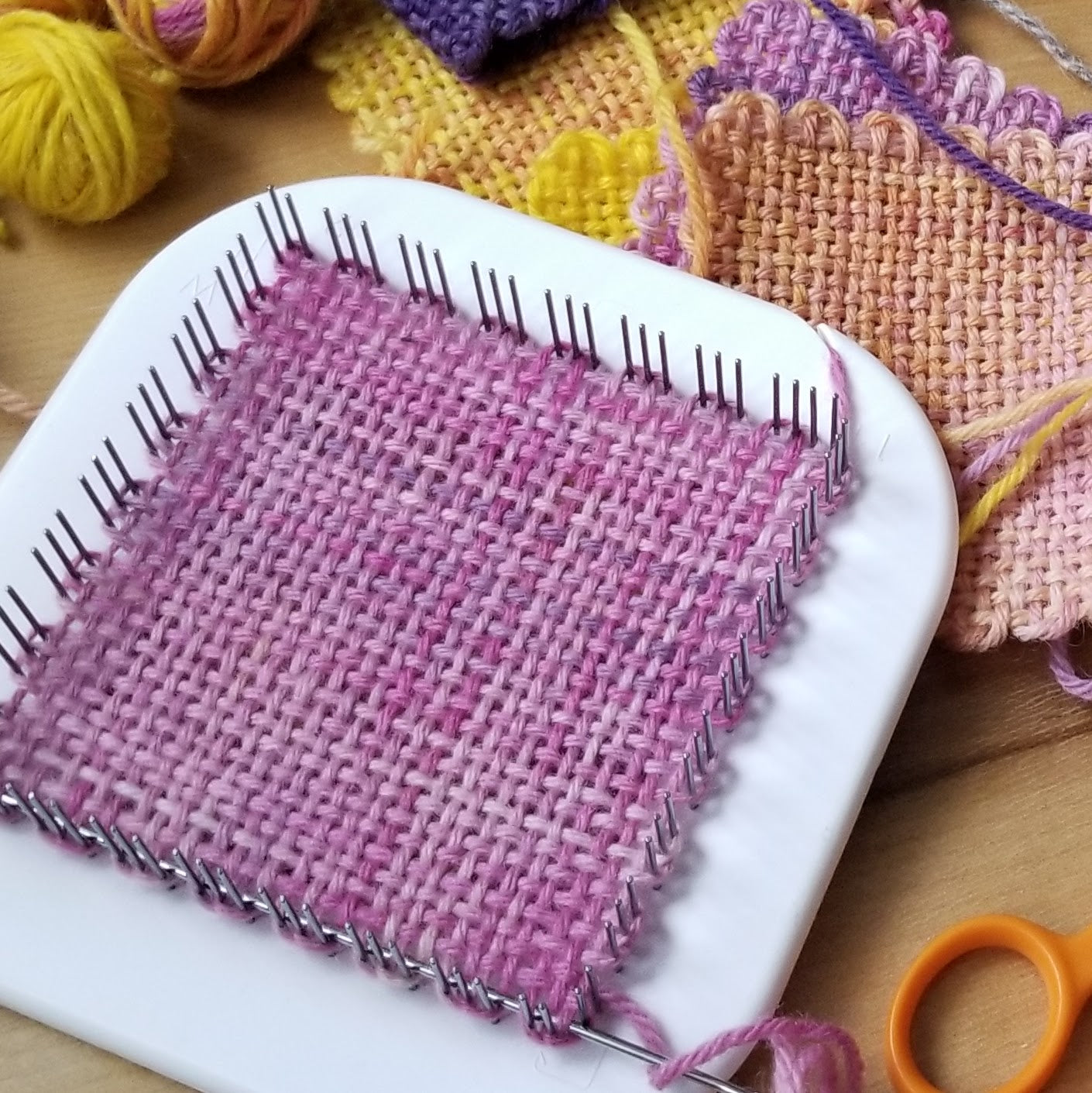 Weaving on a Zoom Loom with pink yarn
