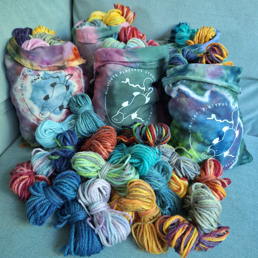 One set of 25-squares yarn in the foreground with additional sets in project bags in the background