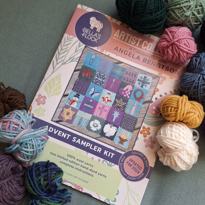 Advent Sampler Pattern Book with yarn balls on a textured surface