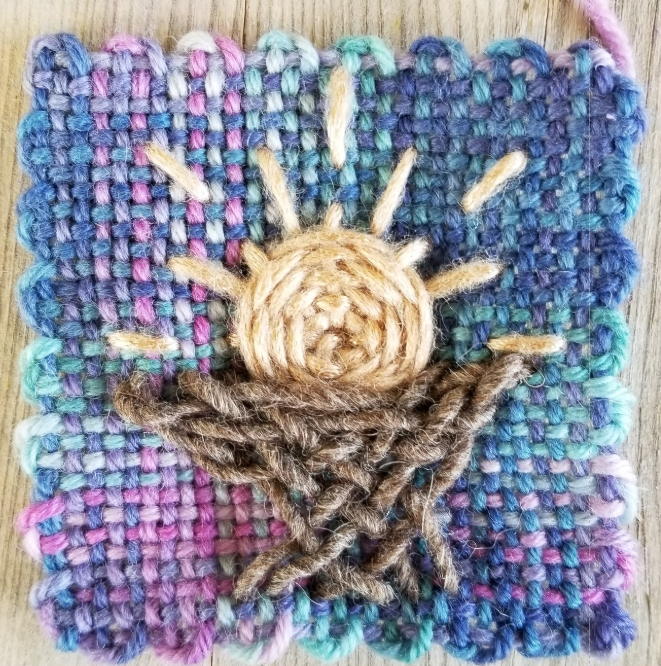 Christmas manger embroidered on a woven square