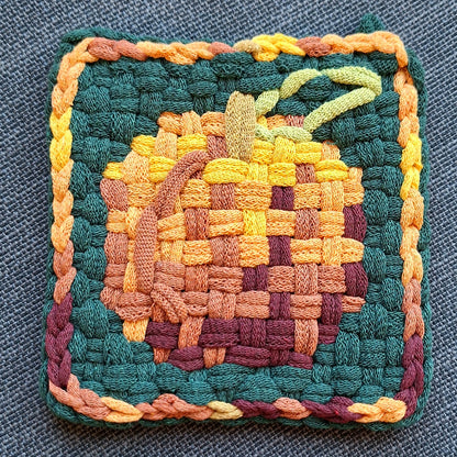 Woven potholder with a peach graphic