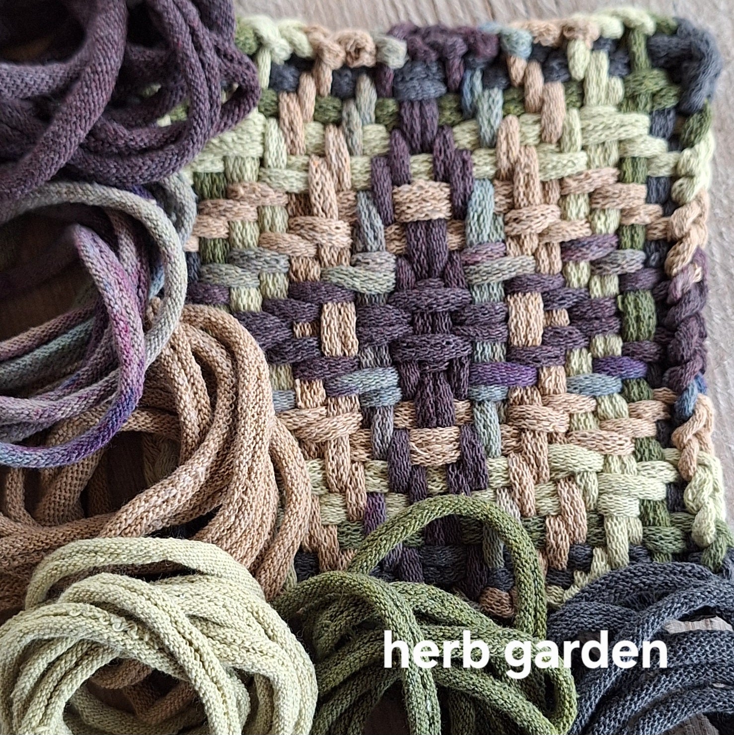 handwoven potholder with muted colors  and 'herb garden' text