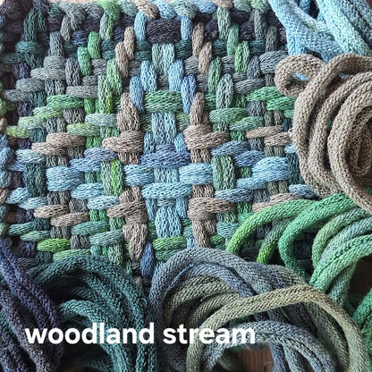 Textile with woven pattern labeled 'woodland stream'.