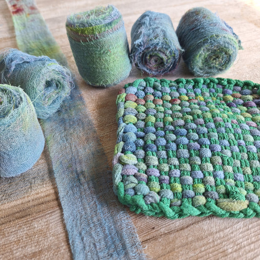 rolls of cotton gauze ribbon and a potholder woven with tide pool ribbon and green loops