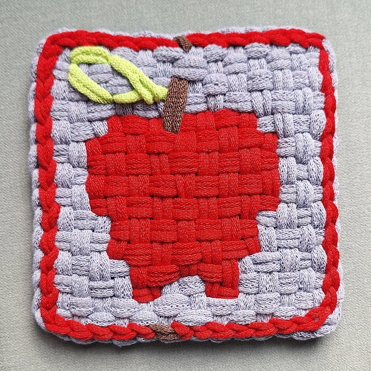 handwoven potholder with an apple image
