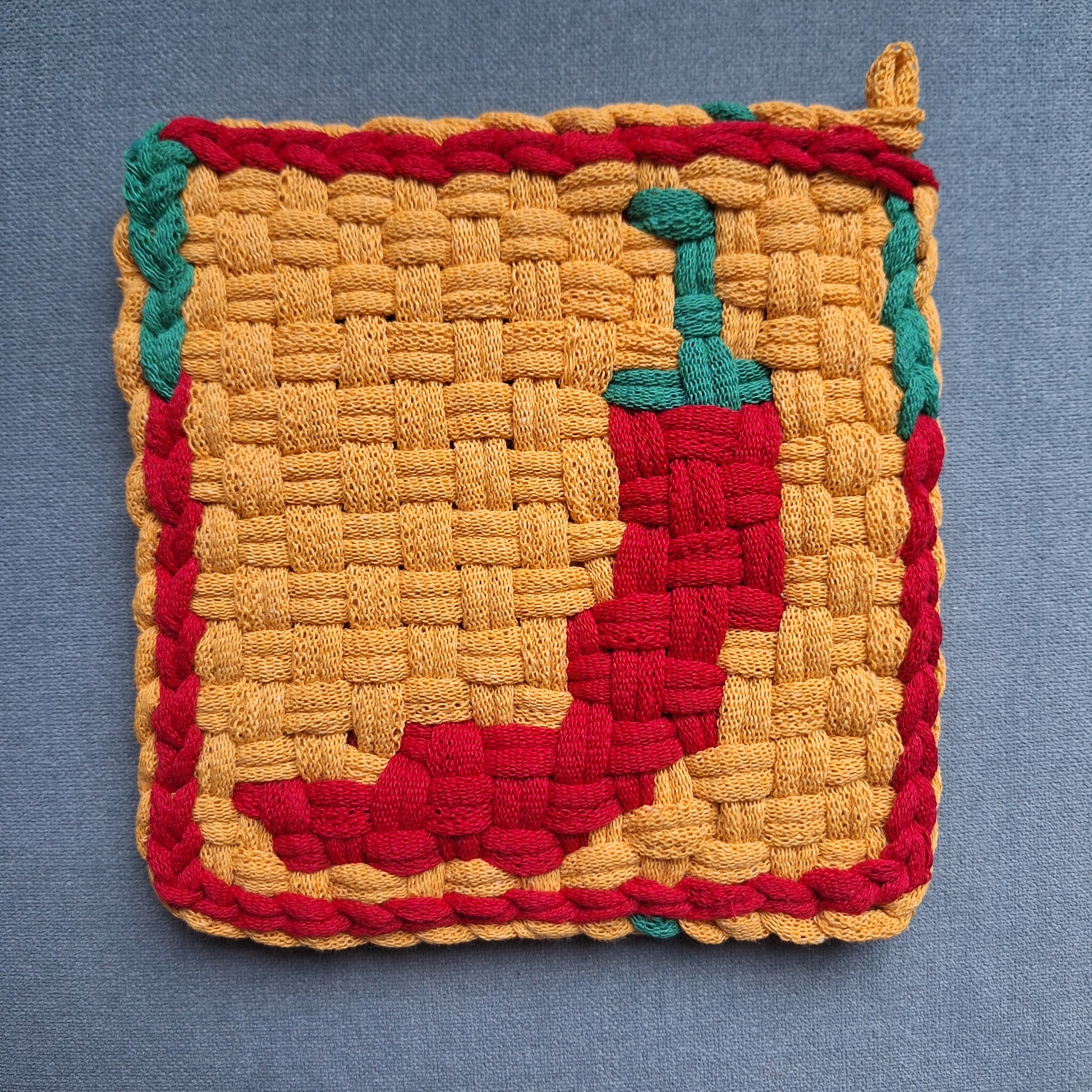 handwoven potholder with a red chili pepper image