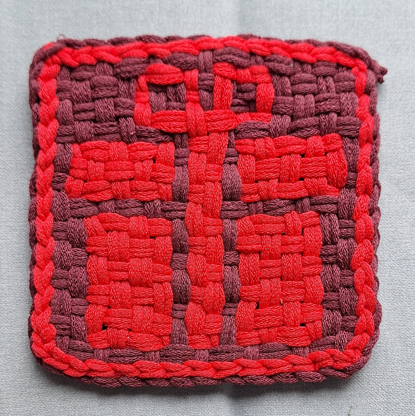 handwoven potholder depicting  gift box with a bow design