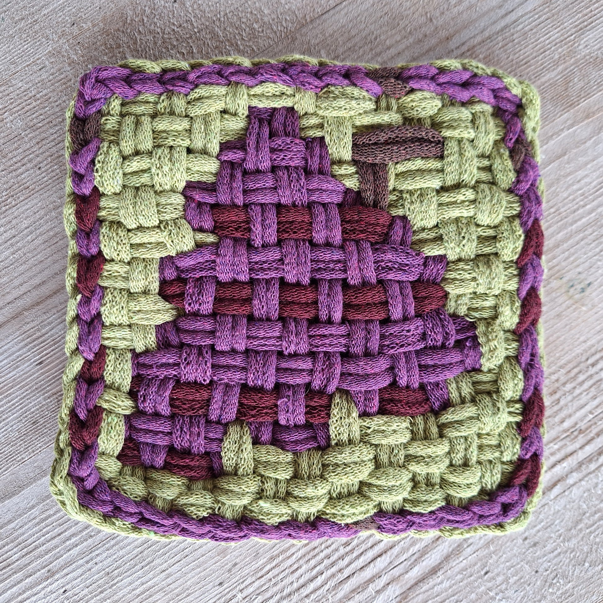handwoven potholder depicting a bunch of purple grapes