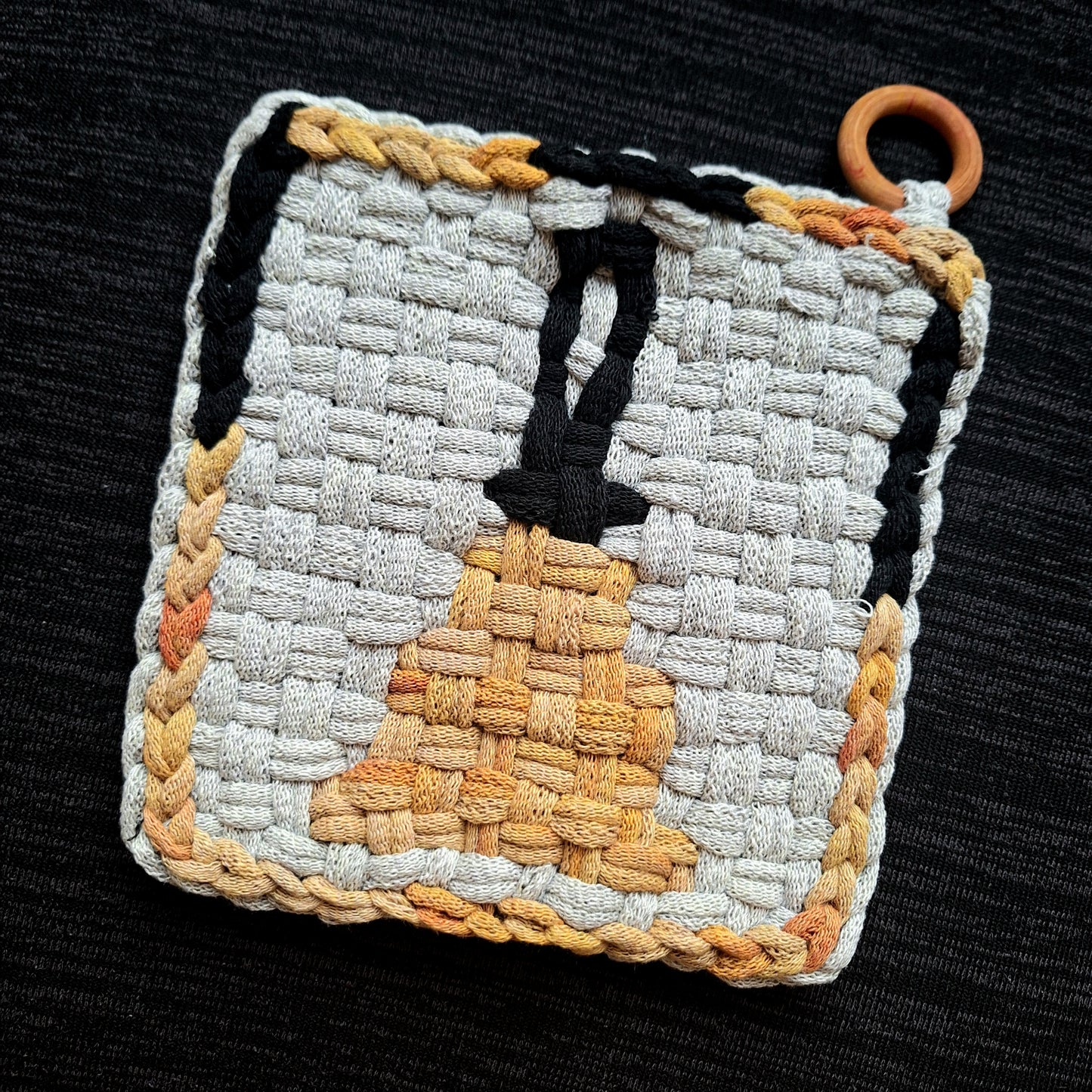 Double weave potholder depicting a handbell