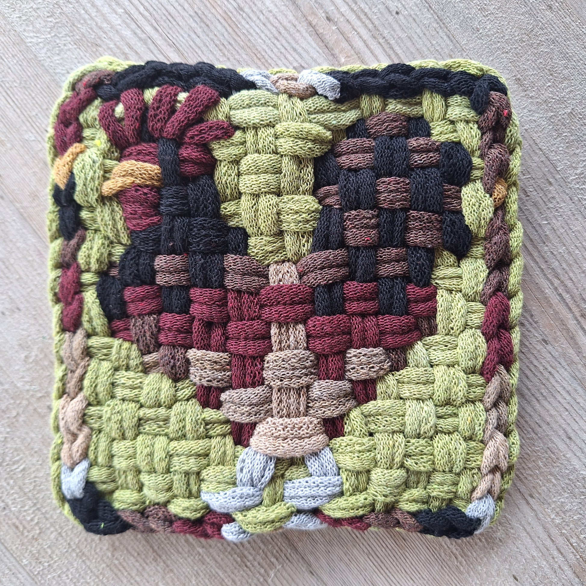 Woven textile with a chicken pattern on a wooden surface