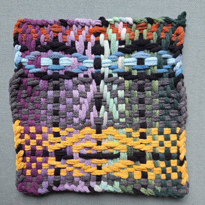 Woven textile with multicolor face pattern on a gray background