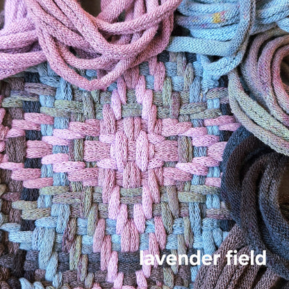 Close-up of woven potholder with lavender and blue loops and the text 'lavender field'.