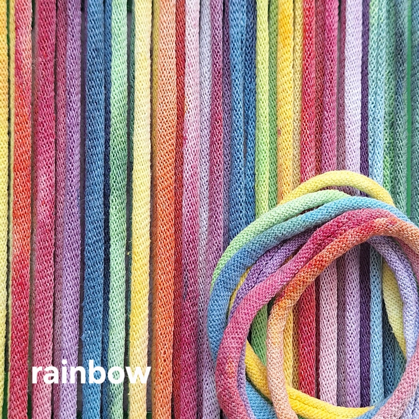 Close-up of colorful potholder loops with a 'rainbow' label.