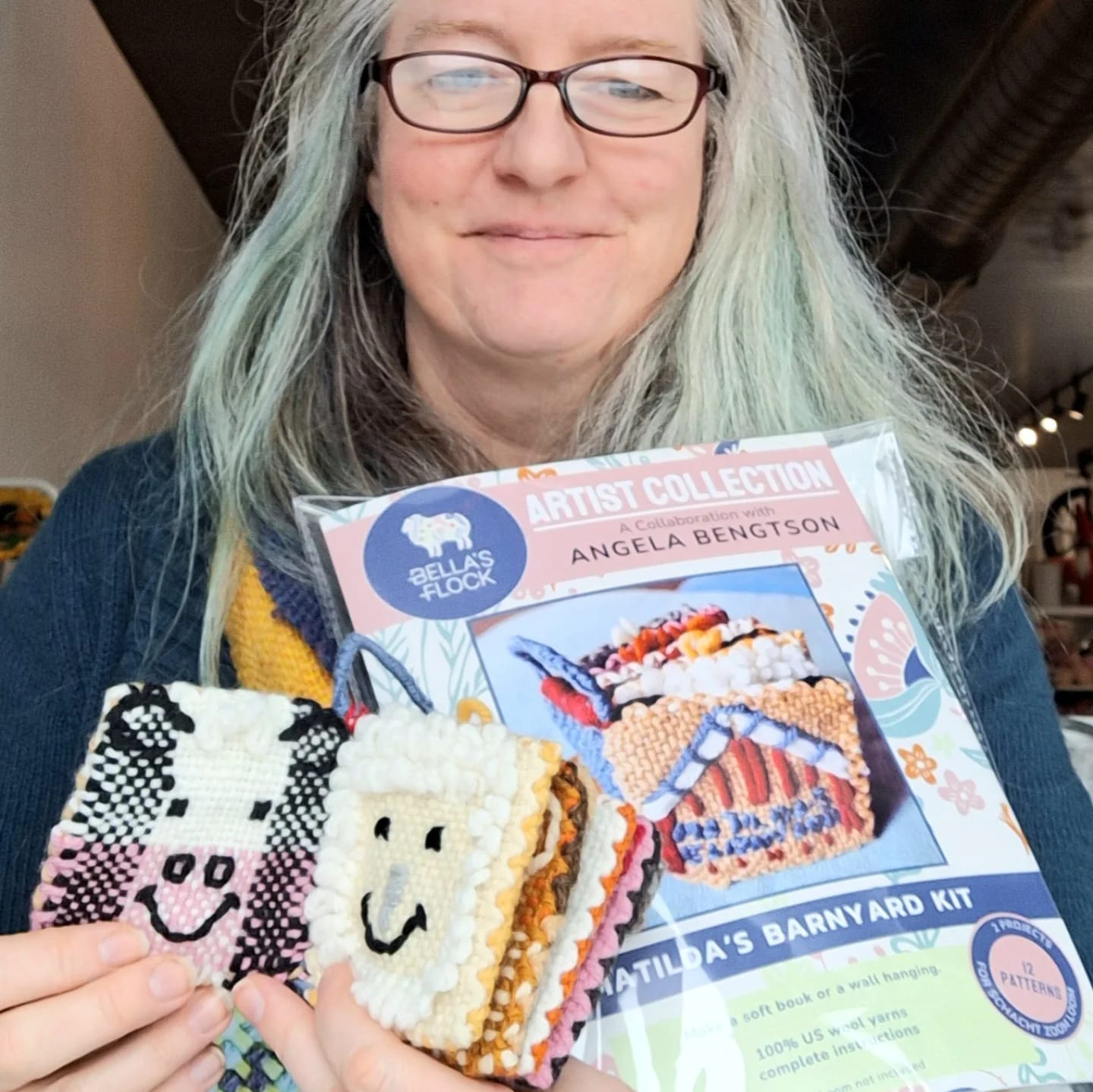 Angela holding a Matilda's barnyard booklet and completed project