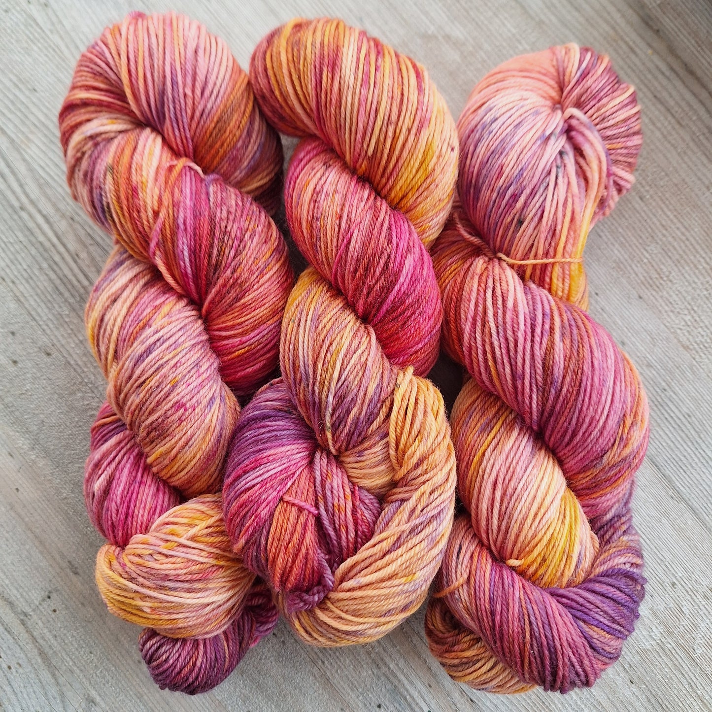 Multicolored skeins of yarn on a wooden surface