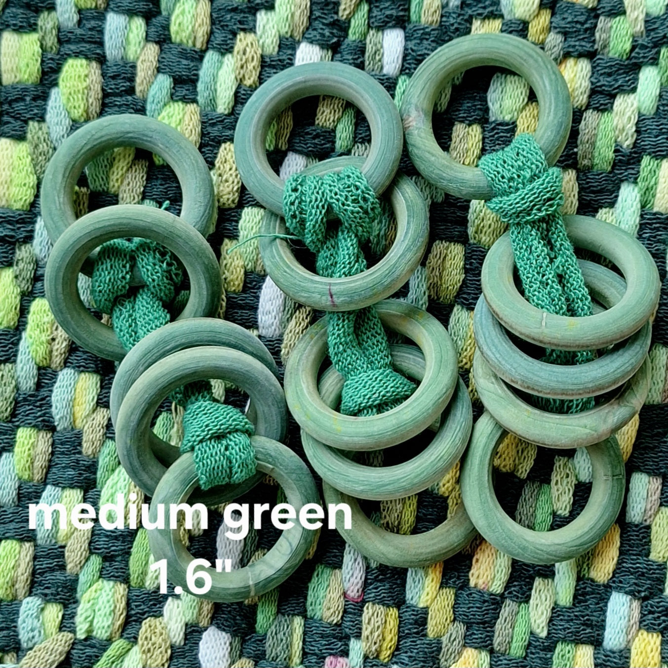 Green wooden rings on a textured fabric background
