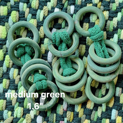 Green wooden rings on a textured fabric background