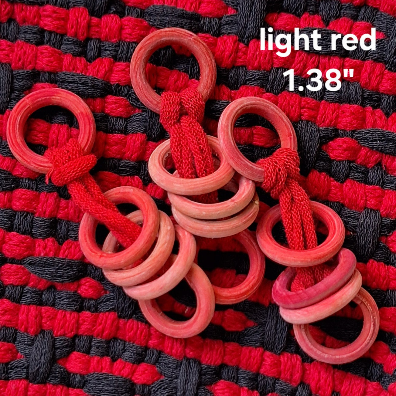 Red wooden rings on a red and black woven background