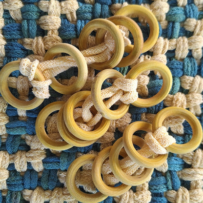 sets of yellow dyed wooden rings on a woven textile background