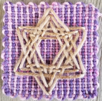 Star shaped embroidery on a pink and purple woven square