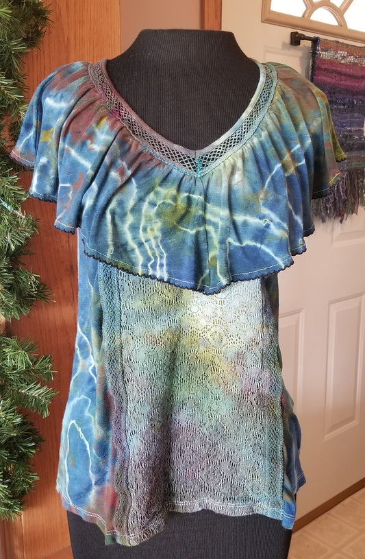 Colorful tie-dye top on a mannequin against a wooden door background