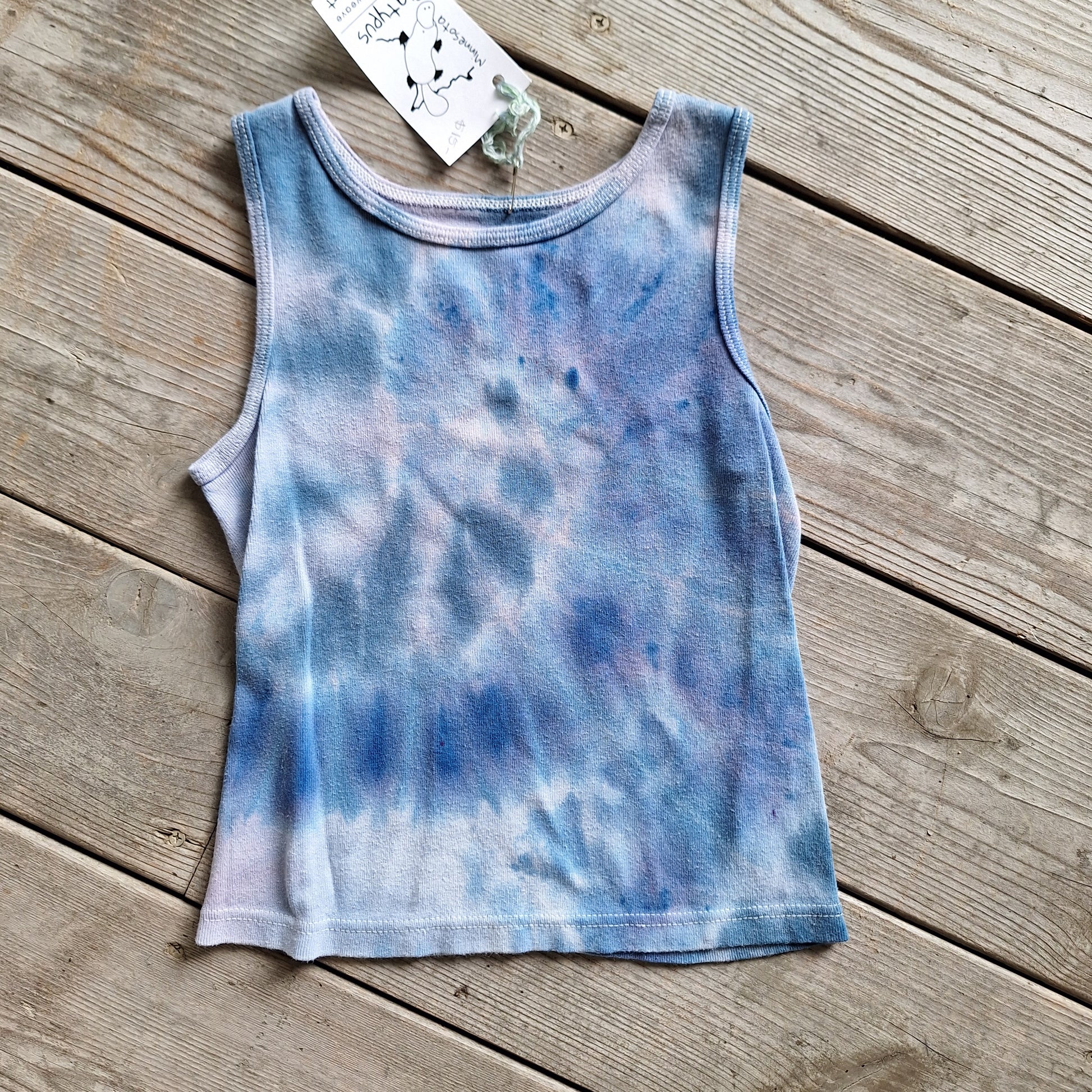 Tie-dye tank top on a wooden surface with a tag attached