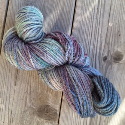 Multicolored skein of hand dyed yarn on a wooden surface
