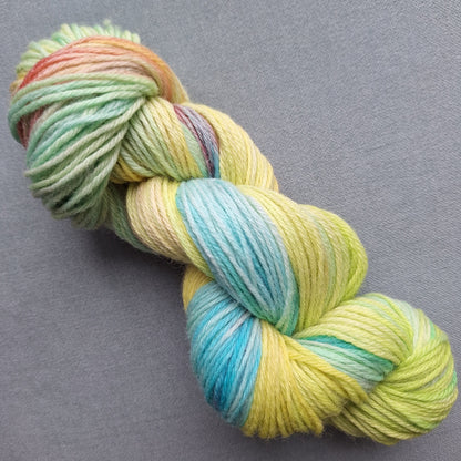 Multicolored skein of hand dyed yarn on a gray background