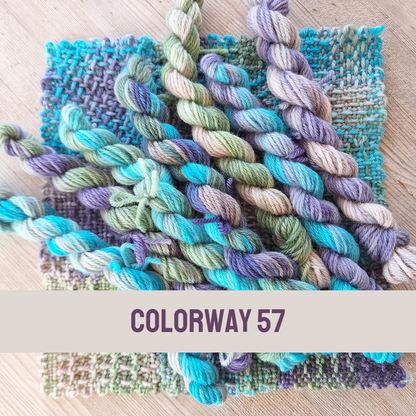 Colorful yarn skeins with woven samples on a wooden surface, labeled 'Colorway 57'.